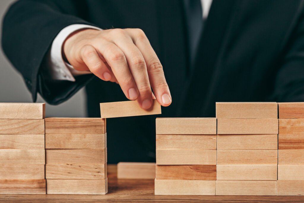 A person arranges wooden blocks and represents the challenges that a person may face in Using No Cautiously in Malaysia