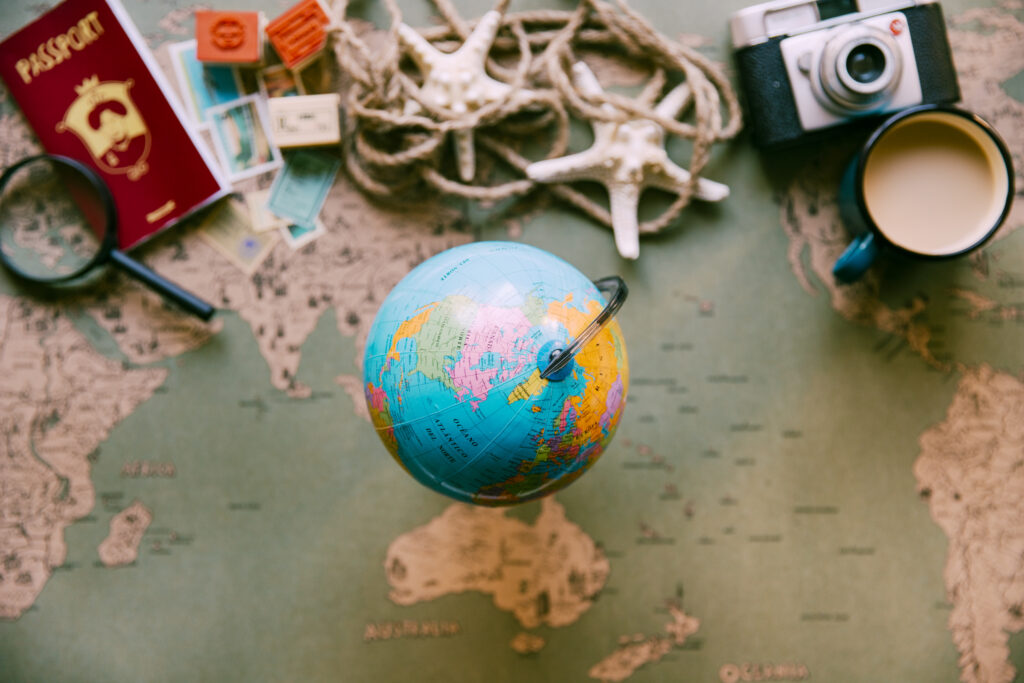 A picture of a globe with a map underneath and a passport on the side