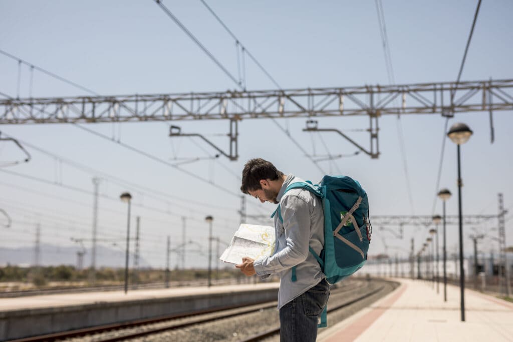 A man holding a map in a train station 